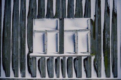 白天冻结的两个白色木框三窗格窗户
